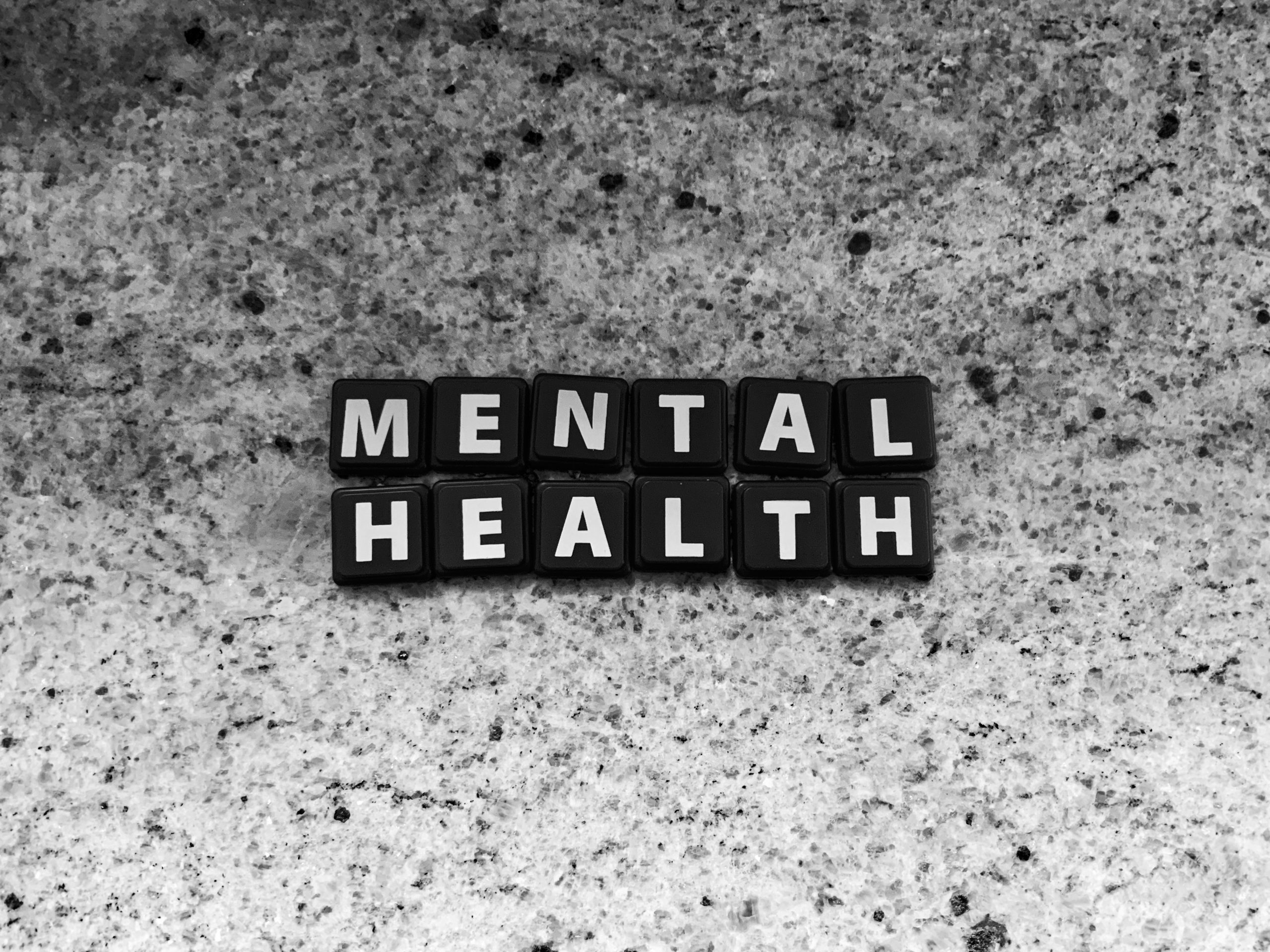 Schwarze Tastenkappen formen das Wort „MENTAL HEALTH“ auf einer Steinfläche – ein starkes Symbol für das wachsende Bewusstsein für psychische Gesundheit. In der Schweiz gewinnt das Thema ADHS stationär zunehmend an Relevanz, besonders im Kontext moderner Therapiekonzepte.