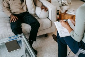 Ein Patient füllt im Gespräch mit der Therapeutin einen Fragebogen aus, ein häufig genutztes Instrument zur ADHS-Diagnostik im Erwachsenenalter.