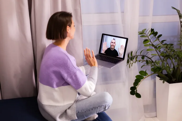 Frau führt zu Hause ein Videogespräch mit einem Arzt am Laptop