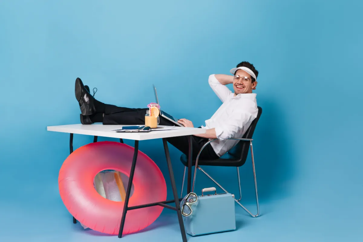 Ein Mann in Businesskleidung sitzt lässig mit Sonnenvisier und Cocktail am Schreibtisch, ein Schwimmring lehnt am Tisch. Work-Life-Balance ist auch bei ADHS Schweiz ein wichtiges Thema, um Überforderung zu vermeiden. Das Bild vermittelt auf humorvolle Weise die Notwendigkeit von Leichtigkeit im Alltag.