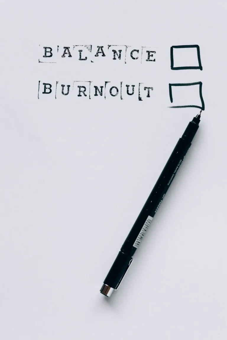 Ein Blatt Papier mit den Worten „Balance“ und „Burnout“, daneben Kästchen zum Ankreuzen und ein schwarzer Stift. Im Rahmen von ADHS Schweiz ist die Balance zwischen Belastung und Erholung ein zentrales Thema, um Burnout vorzubeugen. Die visuelle Darstellung regt zur Reflexion über den eigenen Zustand an.